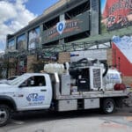 Vacuum excavation truck with workers excavating in front of Chase Field