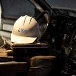 Interior of a vehicle with a hard hat with T2 Utility Engineers logo resting on the center console