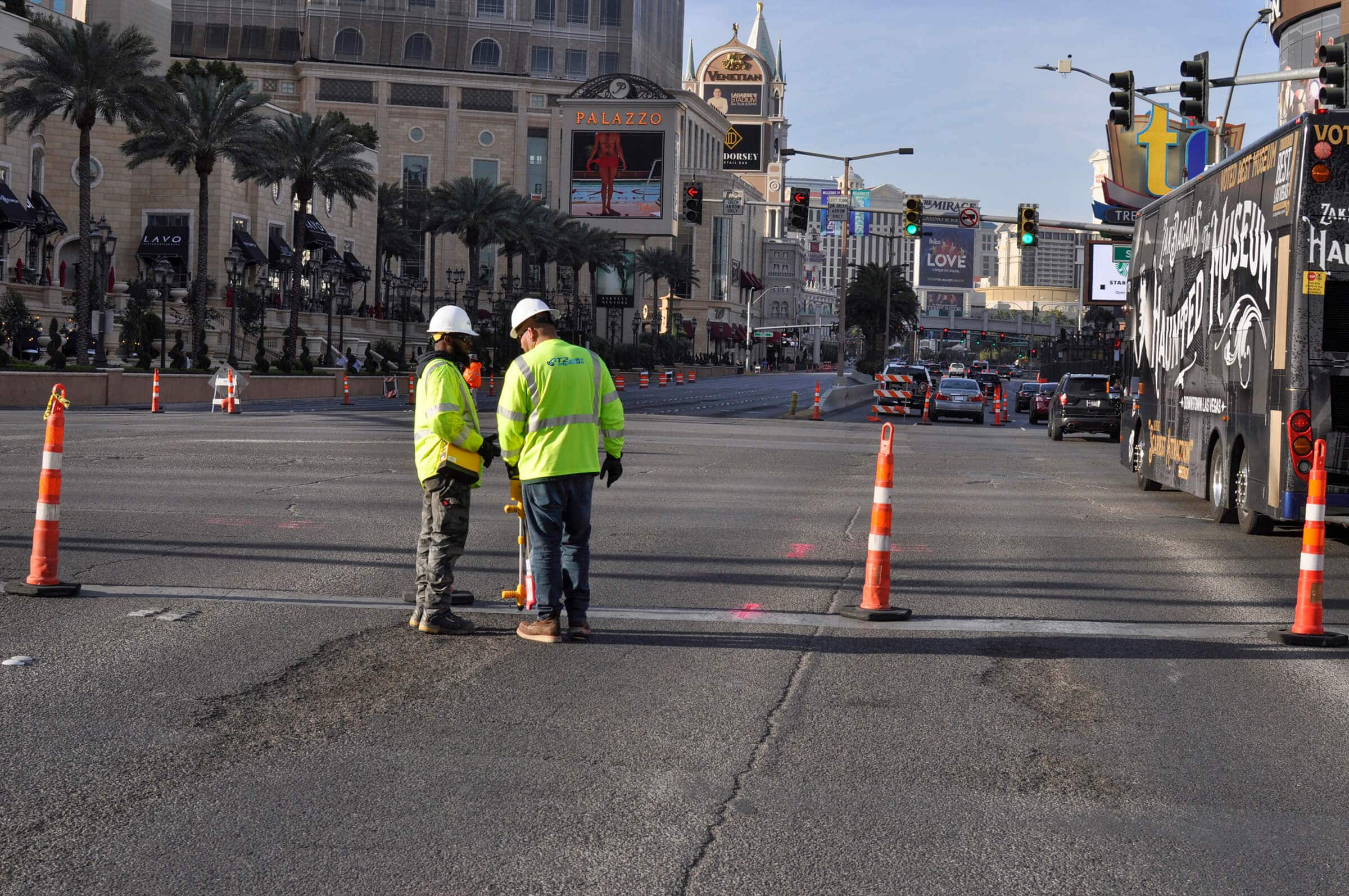 Two field workers looking over a busy Las Vegas roadway in the morning