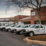 Work pickup trucks lined up in a parking lot.