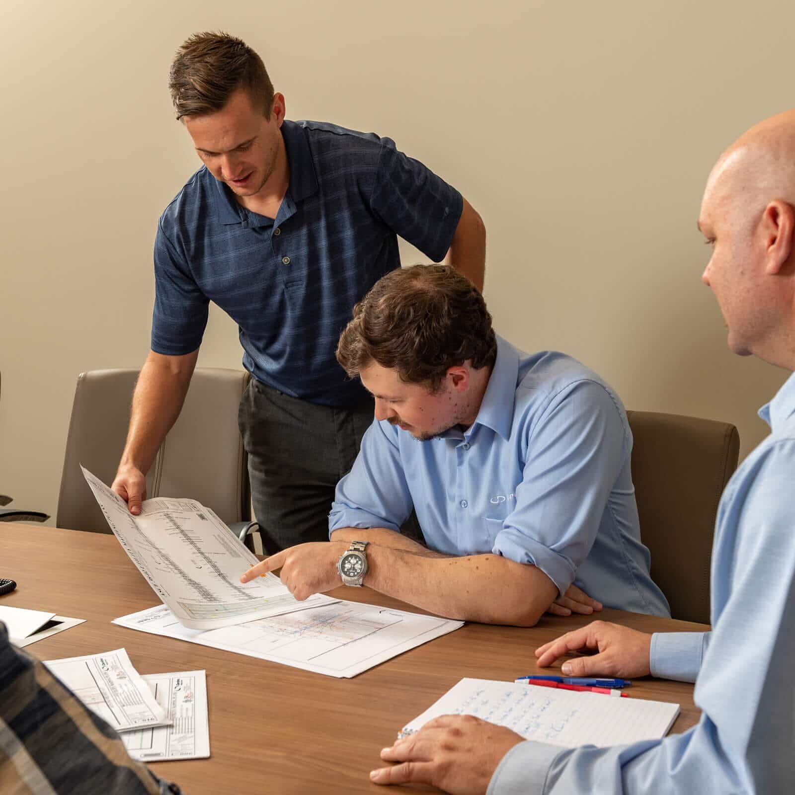 T2ue staff review plans at a conference table